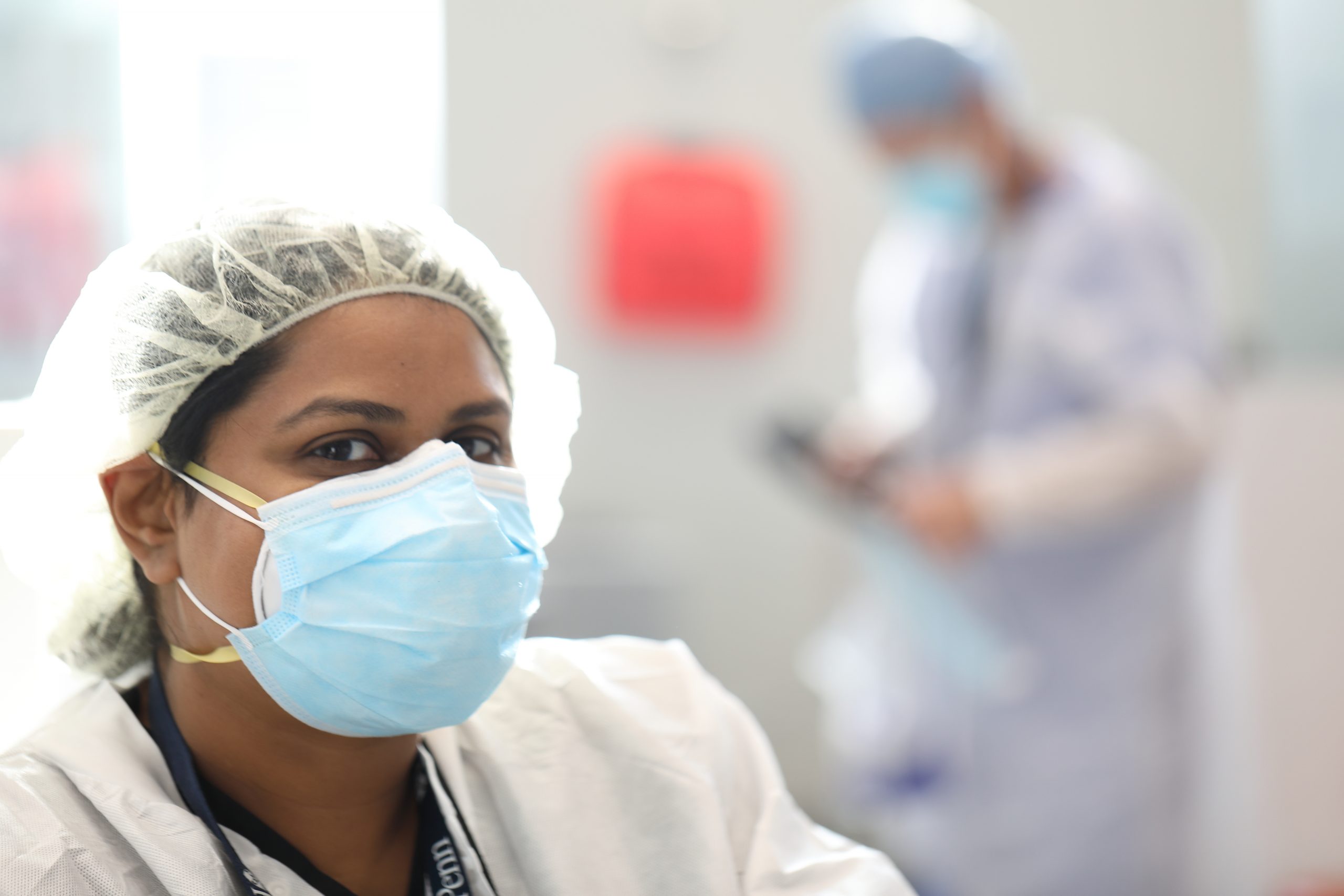 A PDM dentist wears a protective mask and cap as she gets ready to talk to a patient about the importance of flossing. 