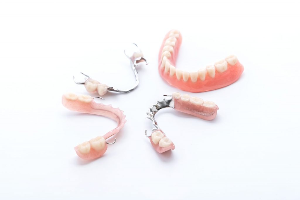 Snap-in dentures vs. traditional dentures are on display together.