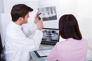 Dentist explaining x-ray image to a patient.