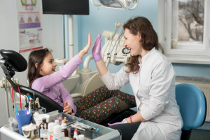 A kid giving high five to a dentist.