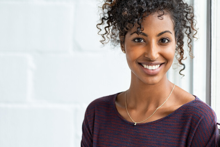 Portrait of beautiful African-American woman with curly hair smiling.