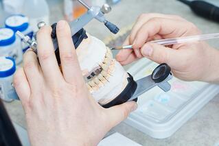 A dentist putting markings on dentures.