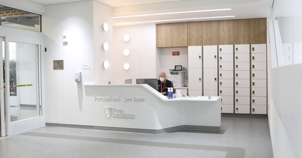 Receptionist at desk of Penn Dental Medicine Personalized Care Suite, where patients with disabilities get specialized care.