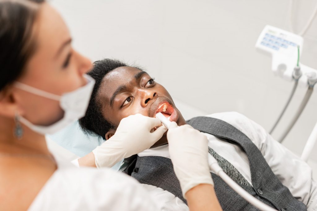 A dentist performs a root canal procedure on a patient.