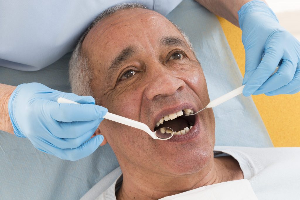 Senior man has a dental exam. 