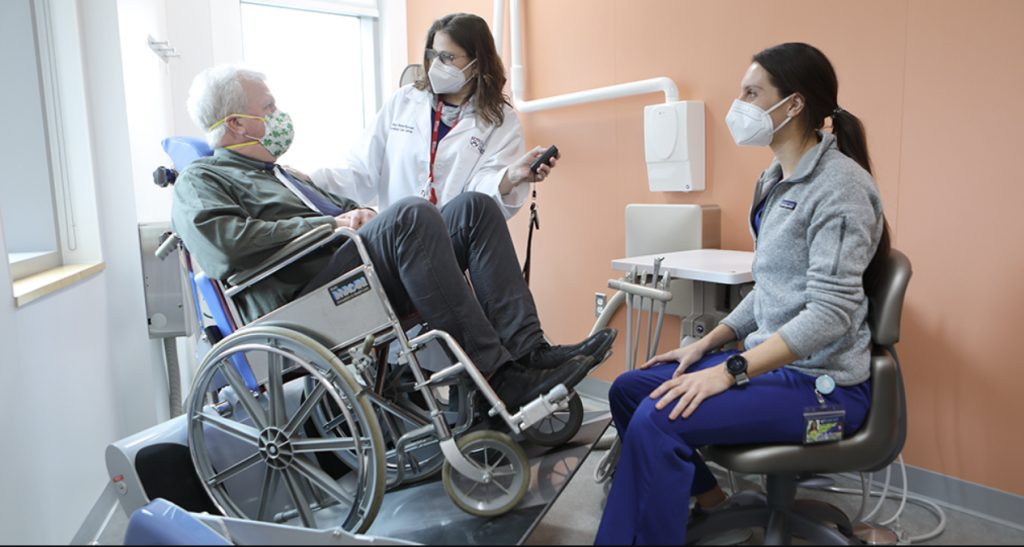 A veteran in a wheelchair has a consultation for his dental needs.