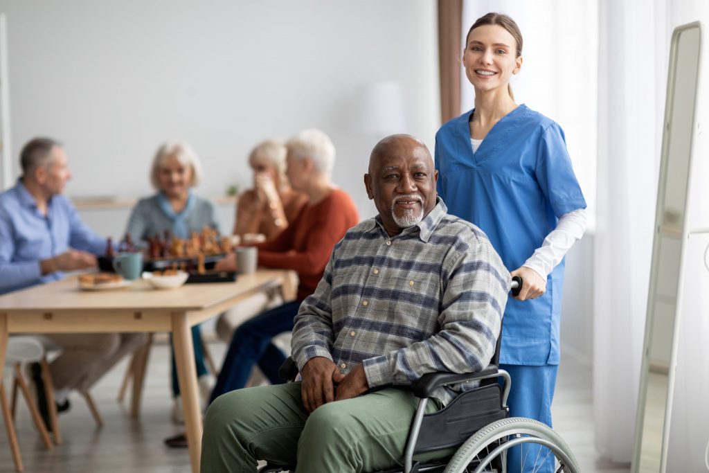 A man in a wheelchair is taken by his aide to a dentist for Alzheimer’s patients.