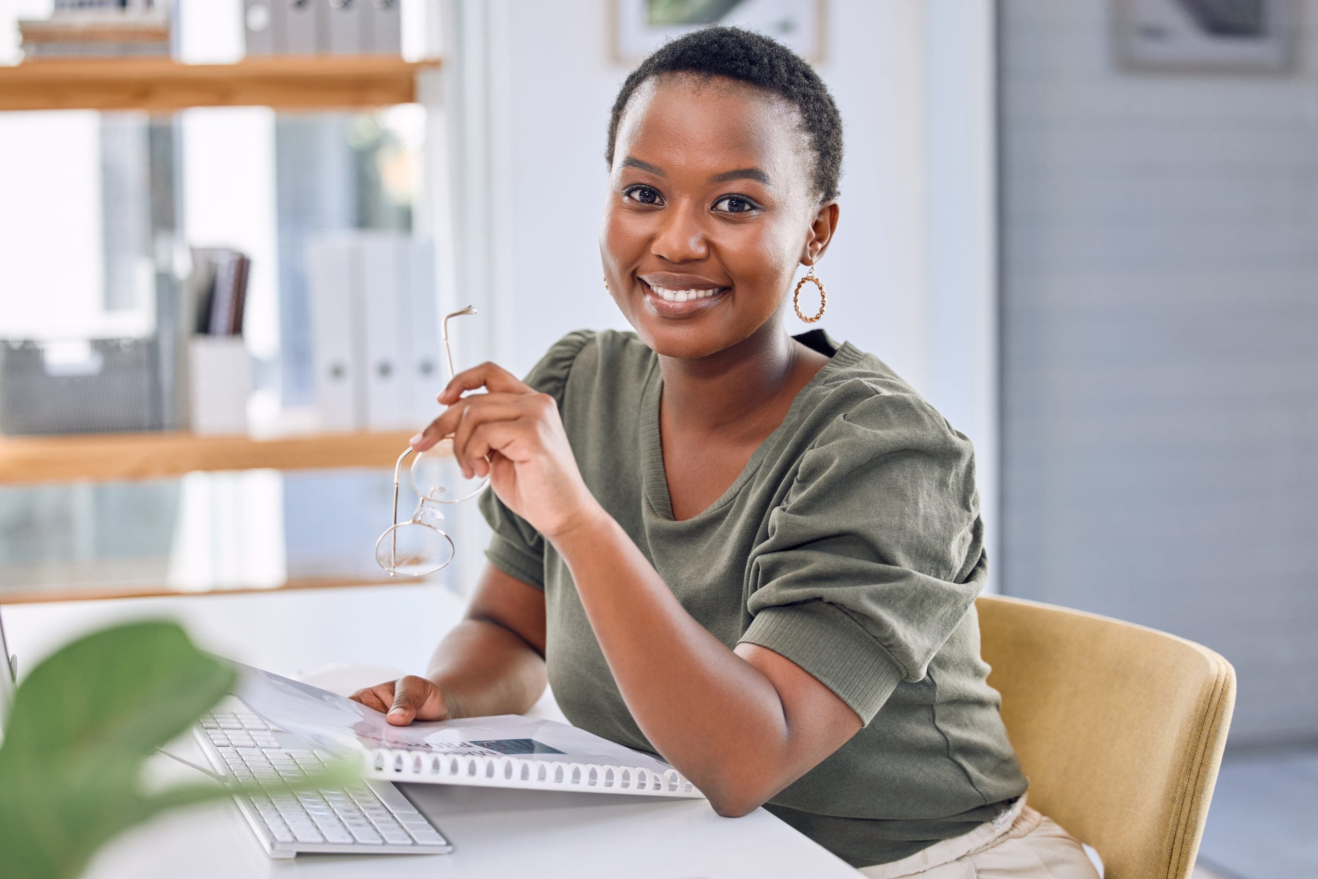 A young woman smiles at her desk now that she’s had oral cancer screening in Philadelphia.