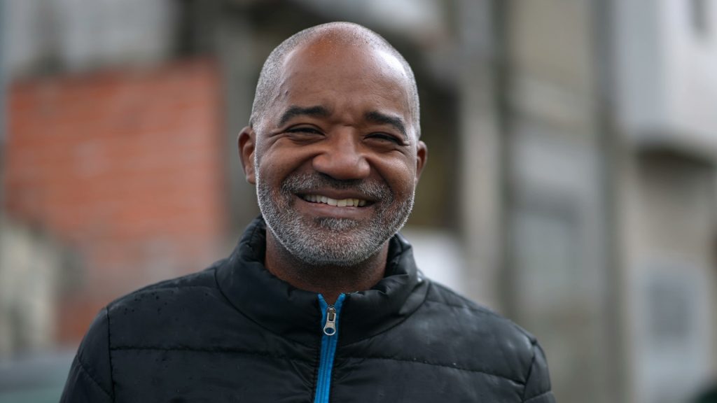 An older adult man smiles after finishing his affordable treatment with adult braces in Philadelphia.