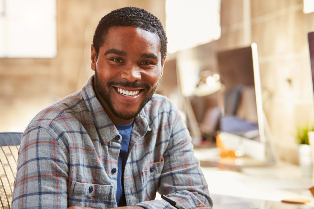 A young man smiles after his successful root canal in Philadelphia at PDM at PHMC on Cedar.