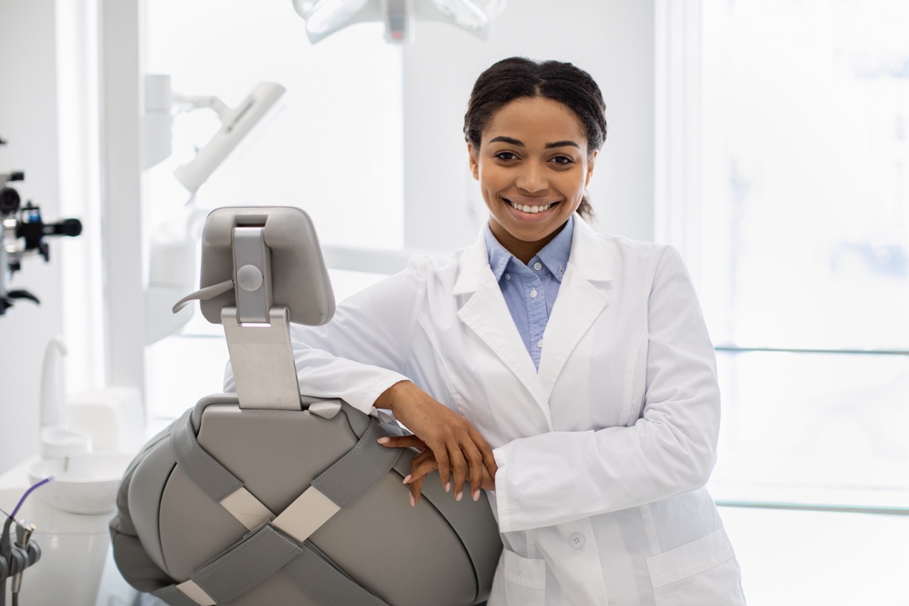 Dental student at Penn Dental Medicine in Philadelphia poses next to dental chair, awaiting her next patient.