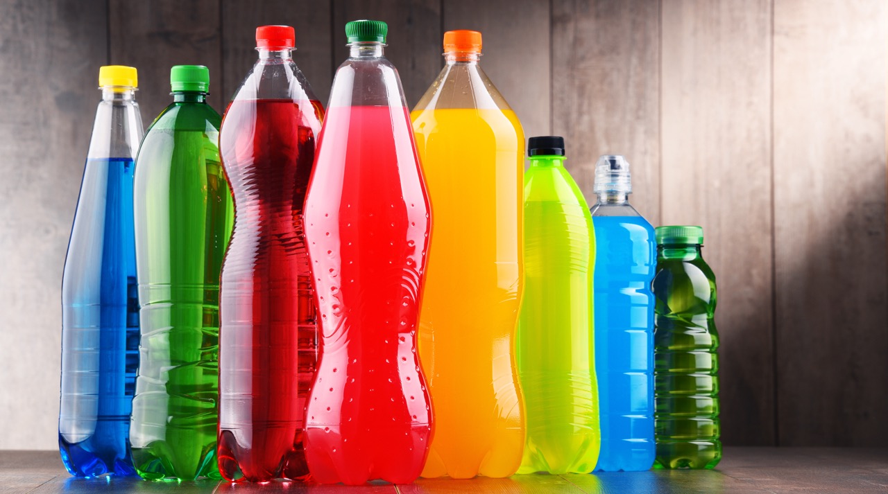 Plastic bottles filled with colorful beverages. 