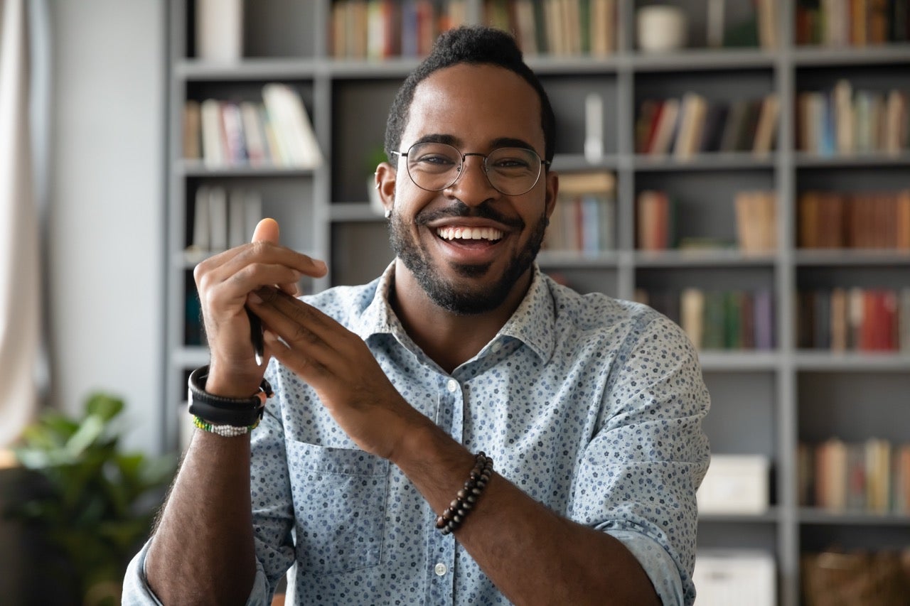 A young man smiles because his teeth are not causing a headache anymore.