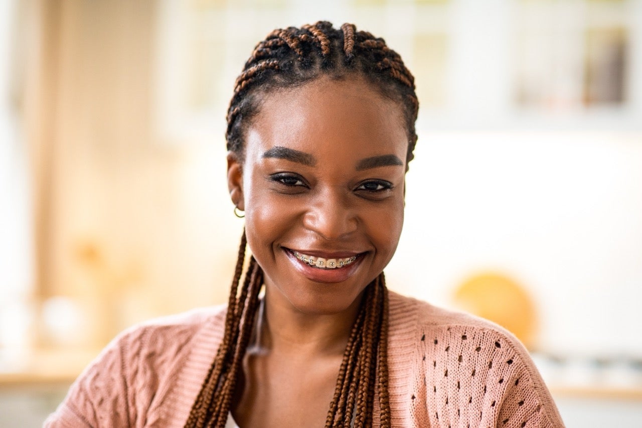 A happy young woman wearing braces smiles after visiting the dentist. 