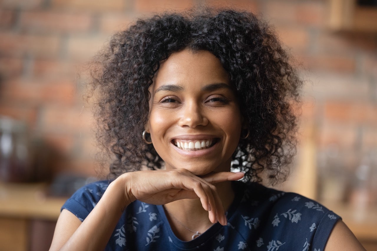 A young woman smiles now that her teeth don’t hurt from eating sweets.