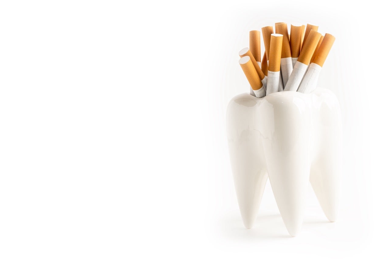 Several cigarettes in a model of a white molar. 