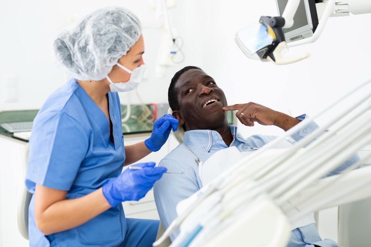 A man talks to his dentist during his dentist appointment. 