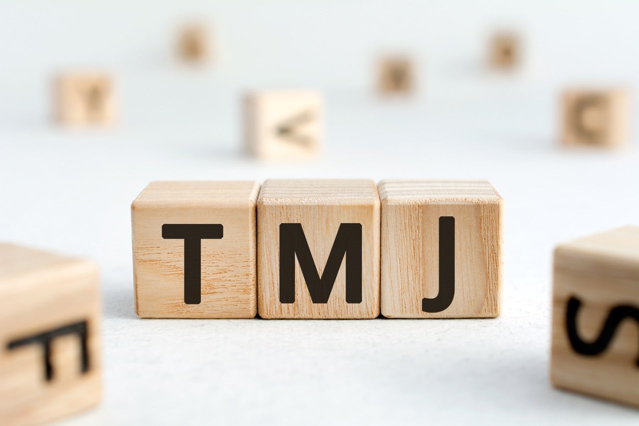 Wooden blocks spell out TMJ.