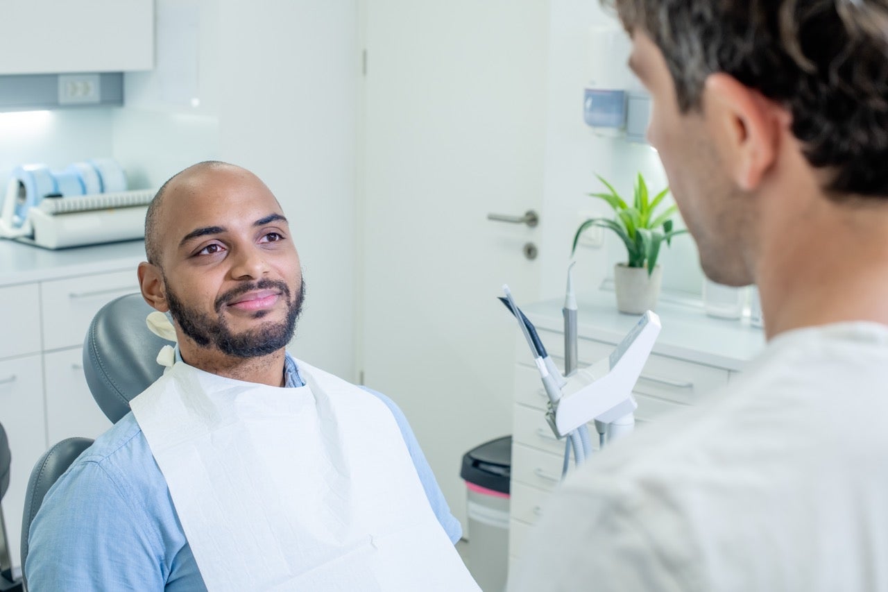 A man talks to his dentist about HPV and oral cancer concerns.